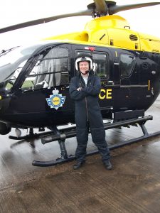 Dr Bennett in front of a helicopter, preparing to fly with the NPAS on an operational mission